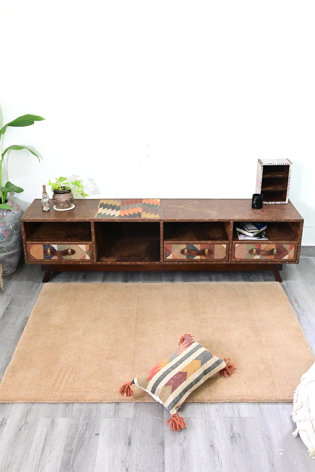 Ranakpur TV unit from above, kilim top inset and distressed leather top panels with brass-studded rails