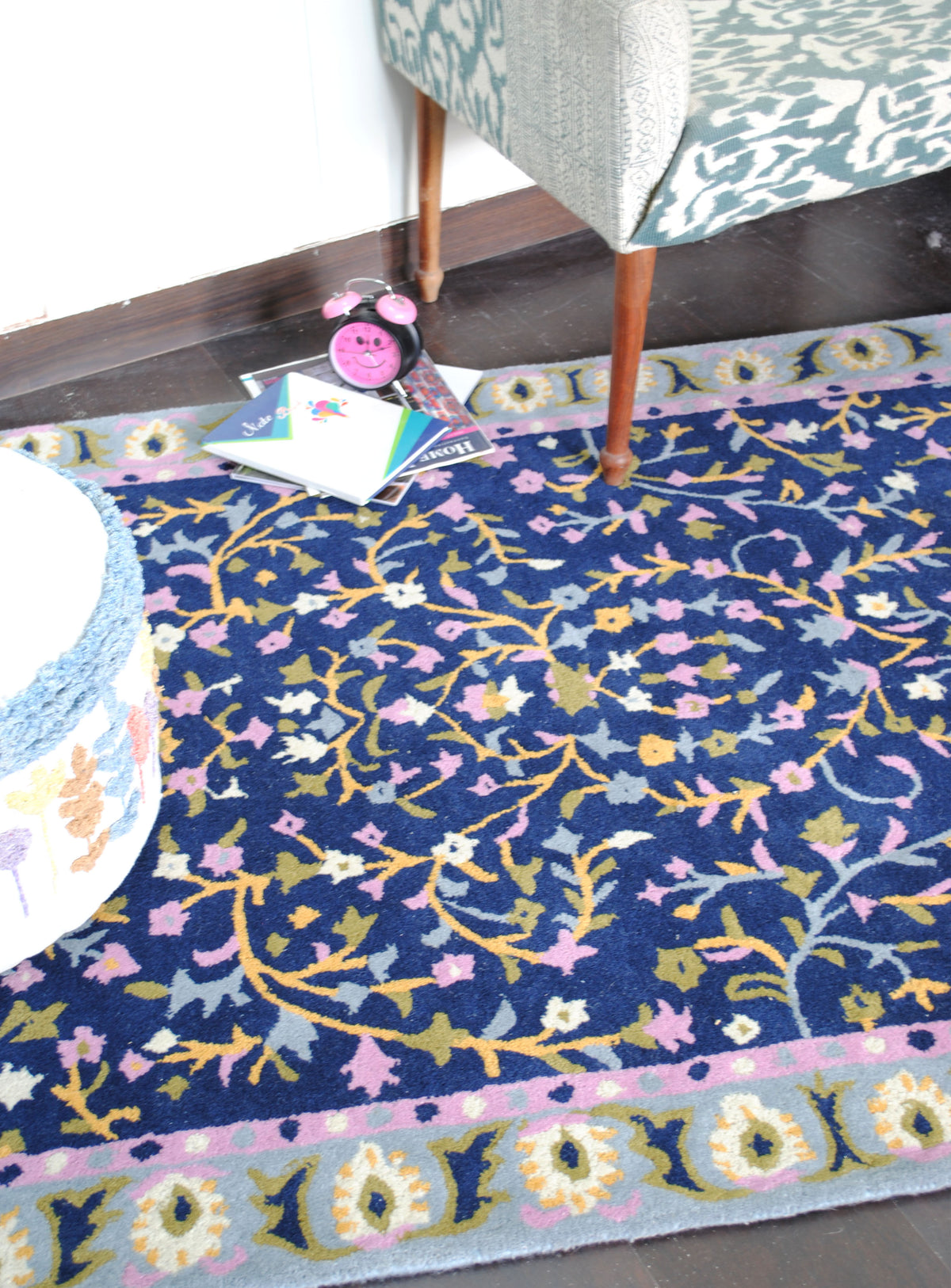 Nishat rug in a room setting, showing the pink inner band and the repeating blossom border