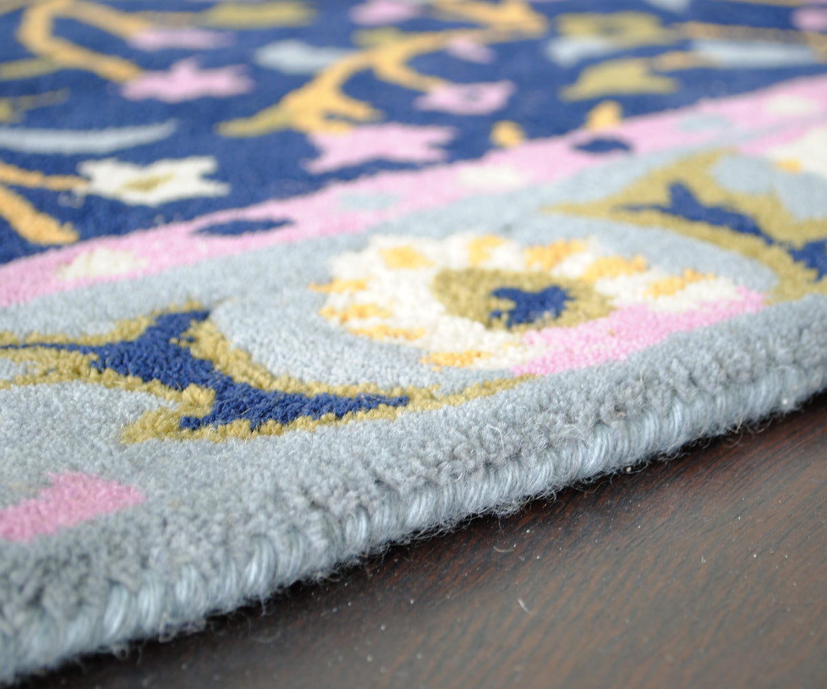 Close-up of the Nishat rug's powder-blue wool-bound edge and tufted pile