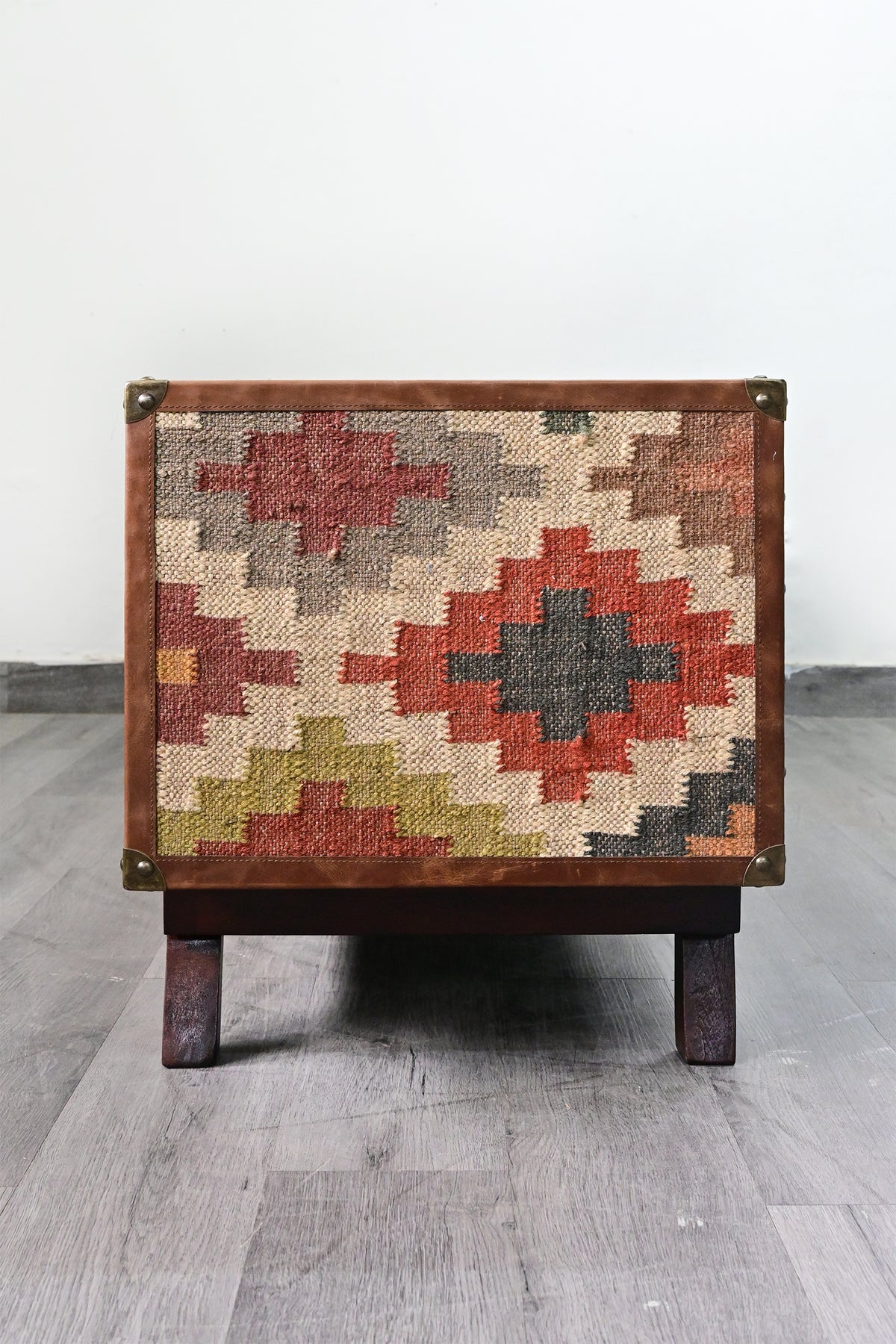 End elevation of the Ranakpur TV unit, full-height vintage kilim panel framed in leather on a solid wood base