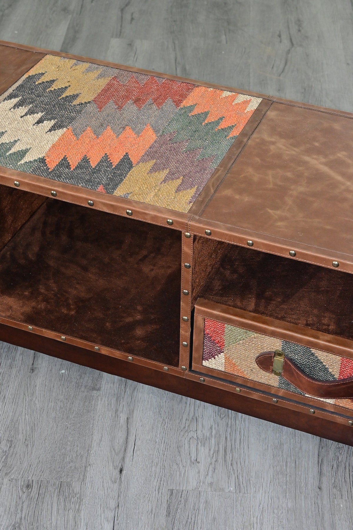 Close view from above of the kilim inset in the Ranakpur TV unit's leather top, beside the full-height open bay
