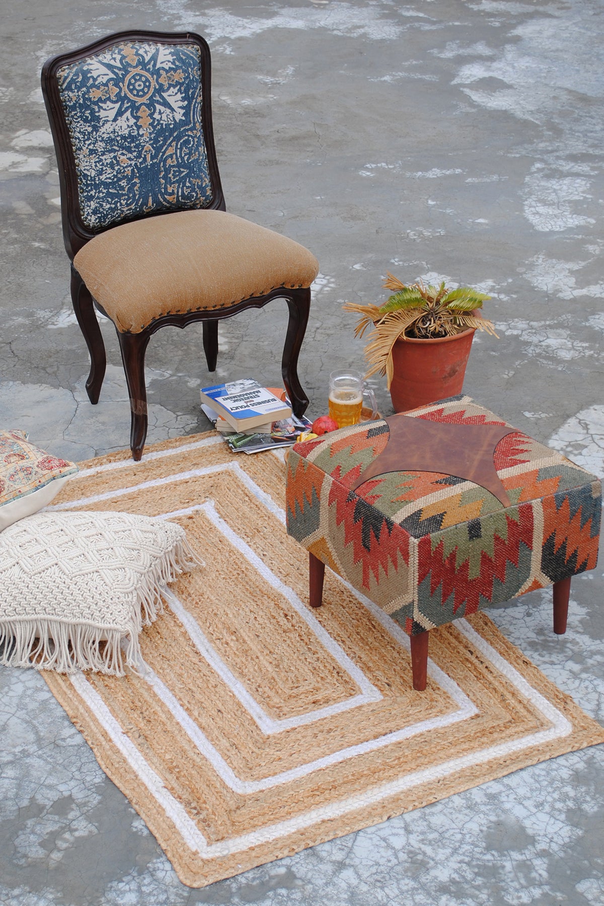 Ajanta kilim ottoman styled in a room with a carved chair, jute rug and cushions