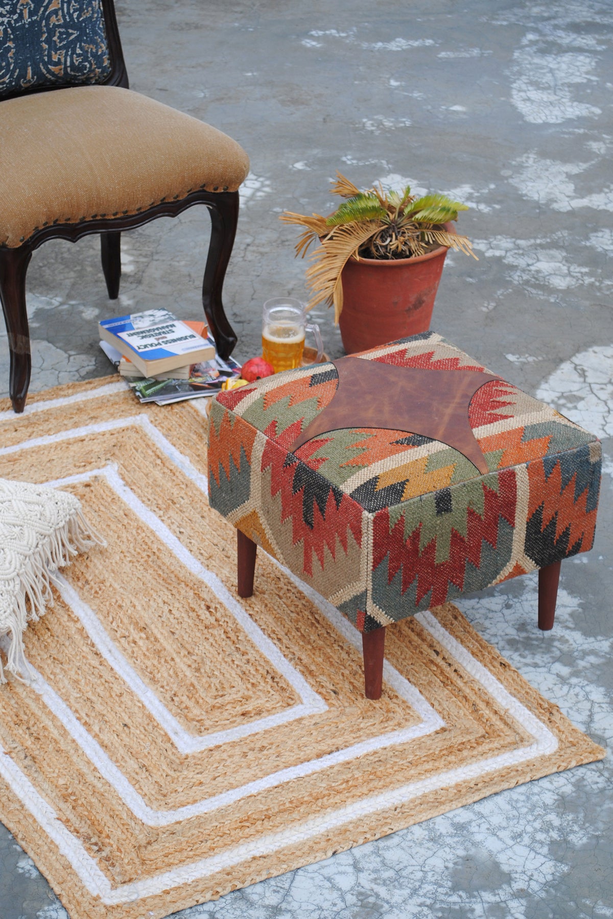 Ajanta medallion ottoman used as a low side table beside a chair