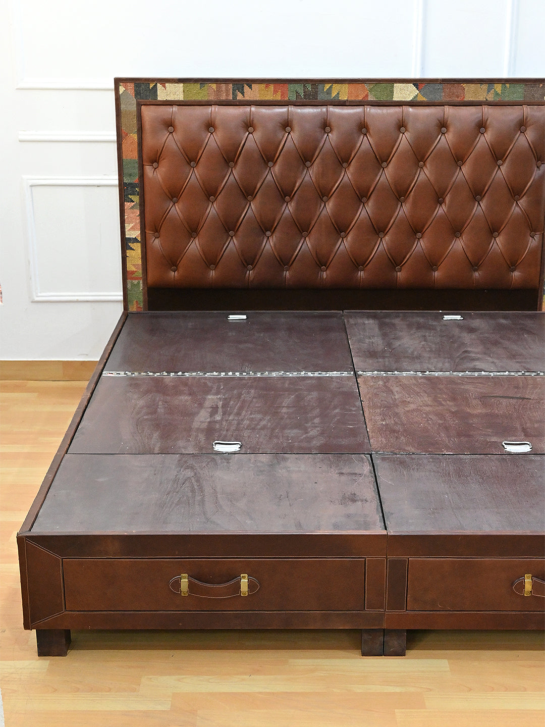 Narlai kilim and leather storage bed by Art Avenue, made to order — leather platform panels closed, showing hinges and lift tabs