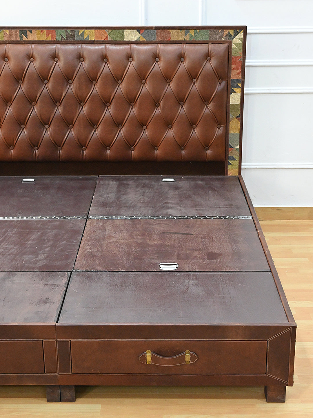 Narlai kilim and leather storage bed by Art Avenue, made to order — detail of a platform lift tab and the drawer front below