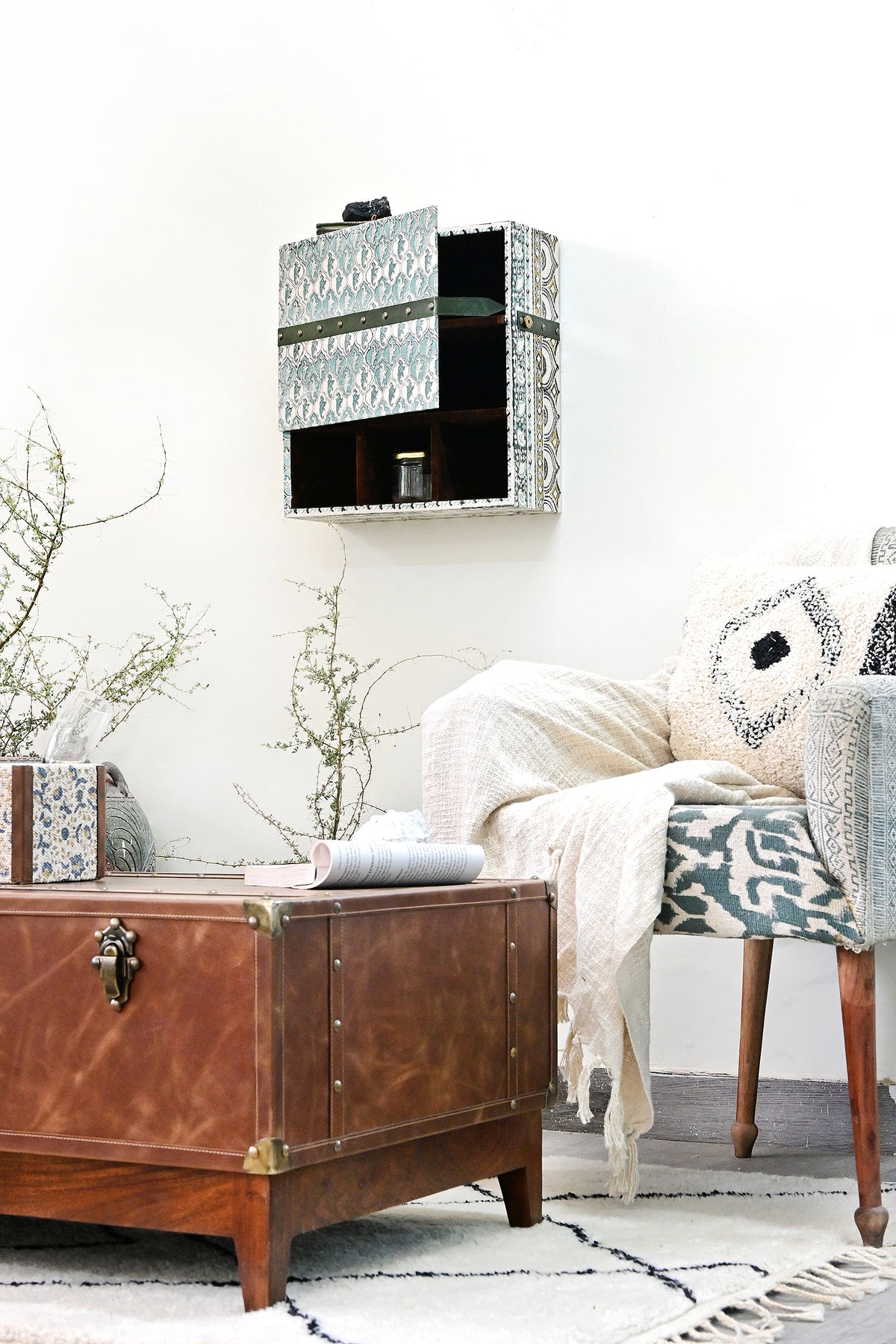 Kuchaman leather trunk coffee table beside a lounge chair, lifestyle detail — Art Avenue, made to order