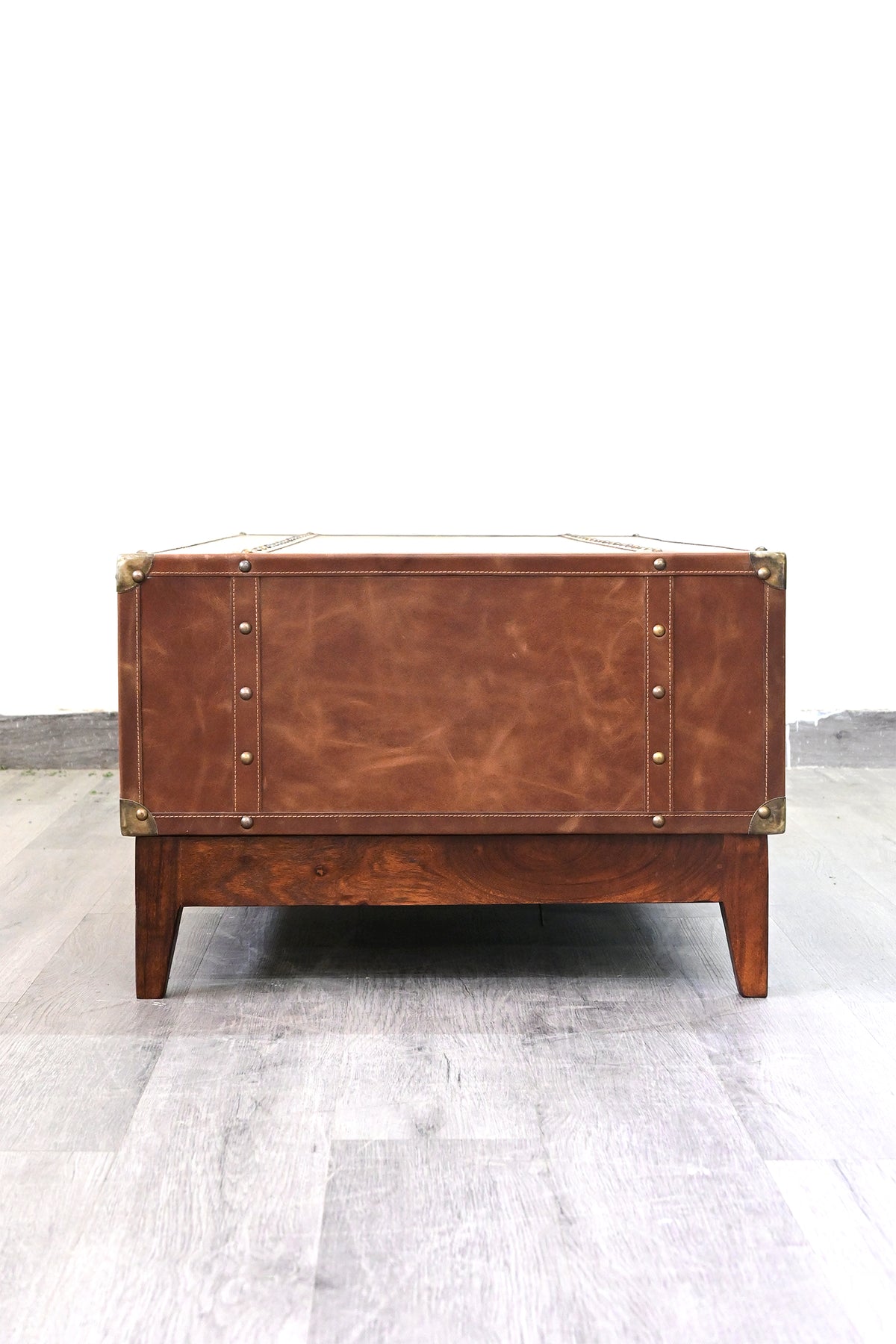 Kuchaman leather trunk coffee table, end view with studded leather straps and metal corner caps
