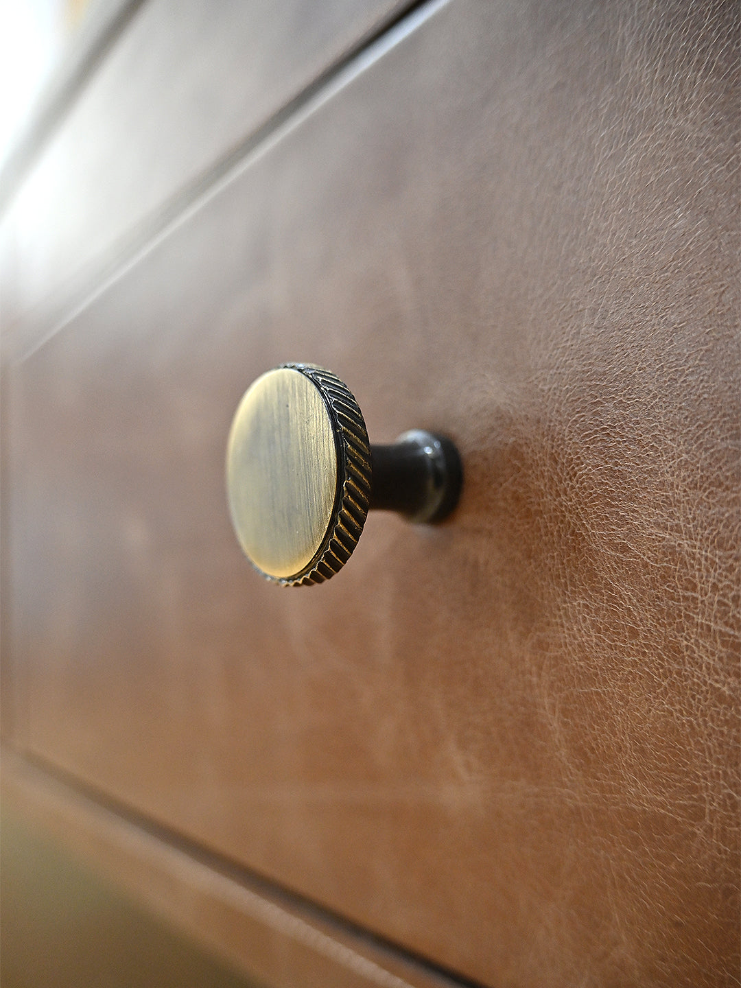 Close-up of the knurled brass knob on a leather drawer front of the Bisalpur coffee table
