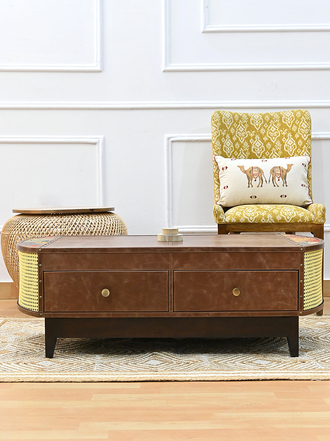 Bisalpur coffee table in a living room with a yellow ikat chair and woven rattan stool, jute rug underfoot