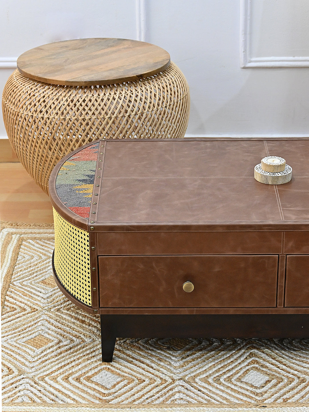 Bisalpur coffee table corner beside a woven rattan stool on a diamond-weave jute rug