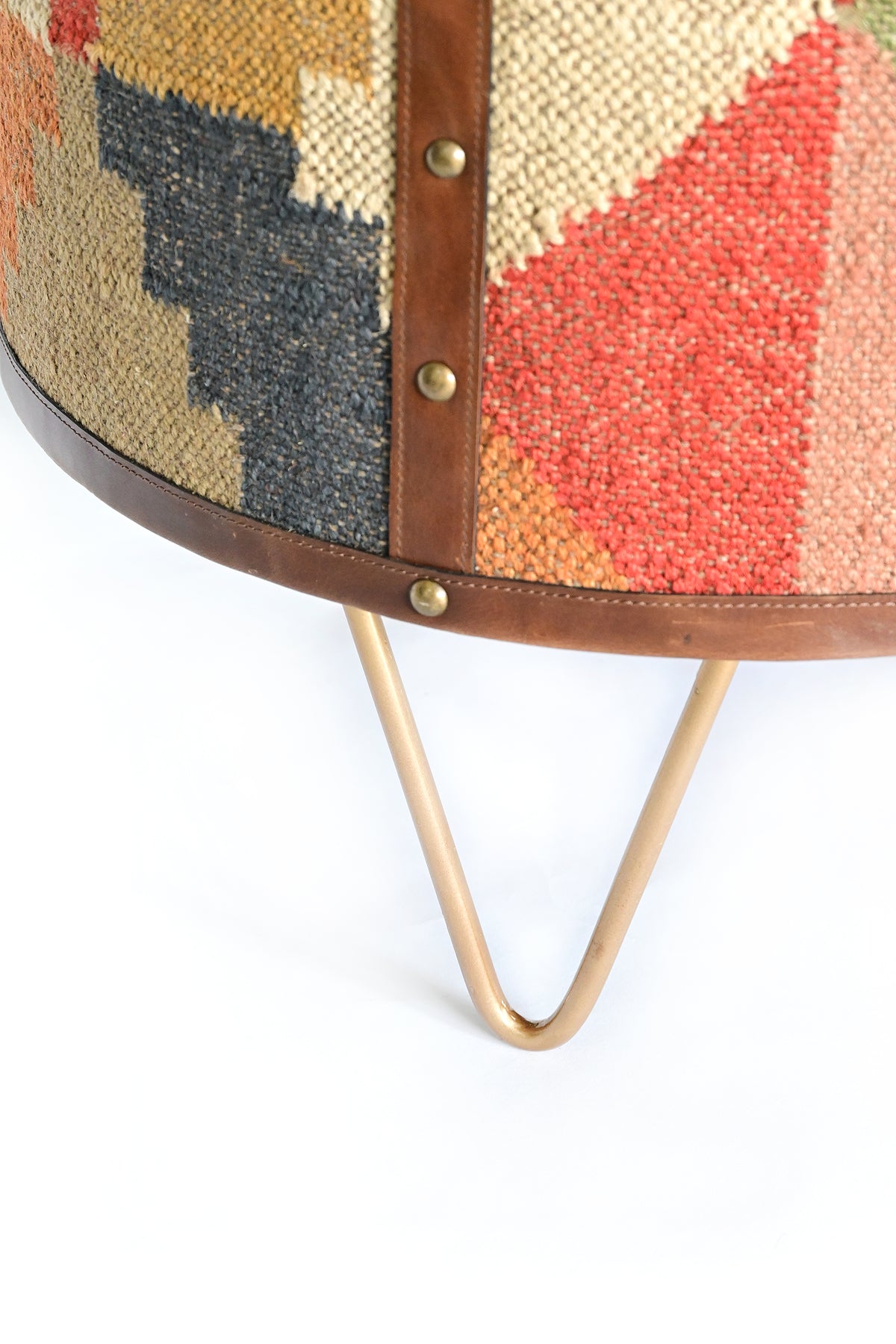 Close-up of the studded leather base band and metal hairpin leg on the Alwar side table