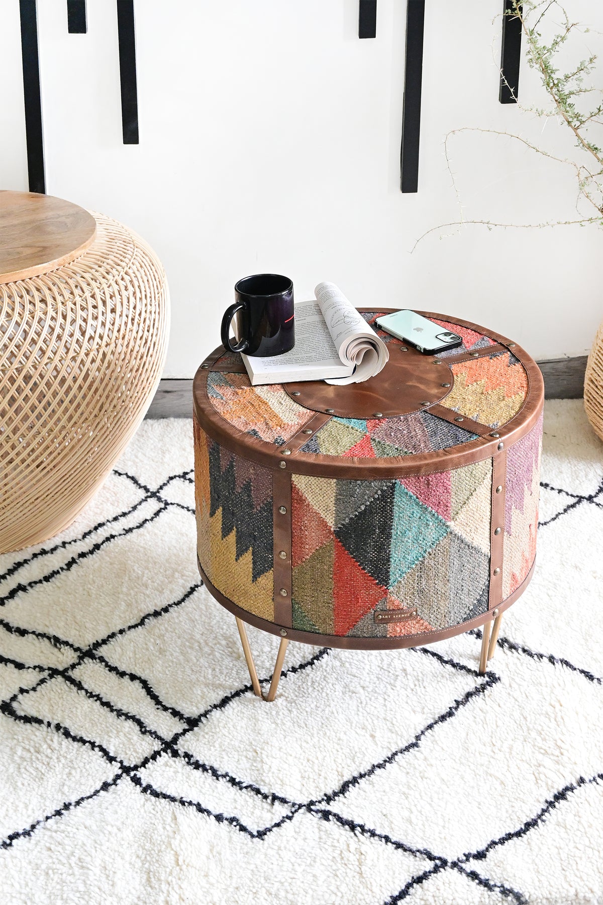 Alwar kilim and leather side table styled on a Berber rug beside a rattan table — Art Avenue, made to order