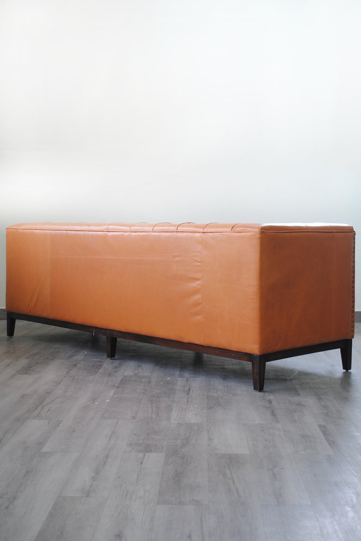 Side profile of the Santiago leather sofa showing depth and the tapered timber legs