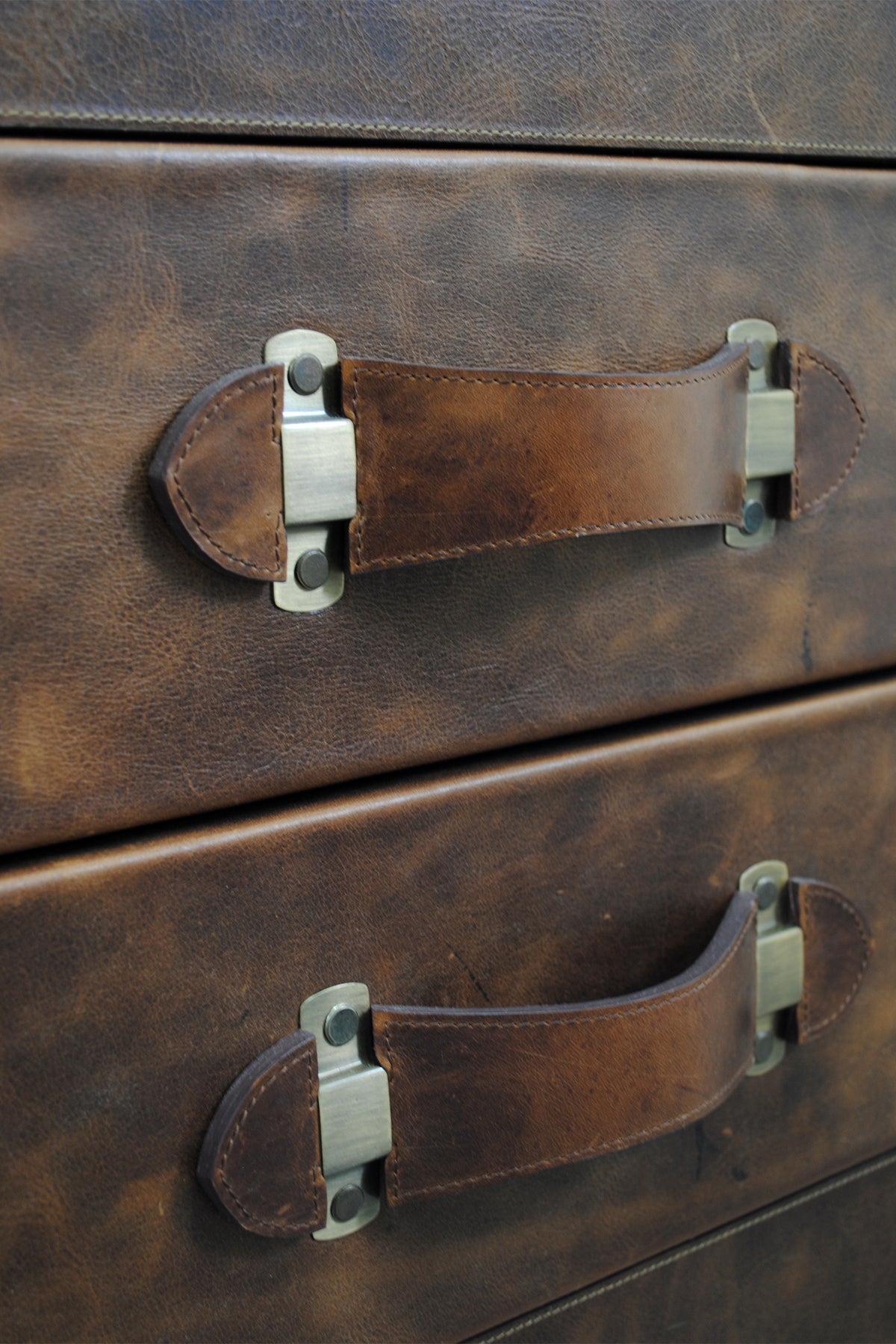 Detail of the recessed leather strap handles on solid brass mounts