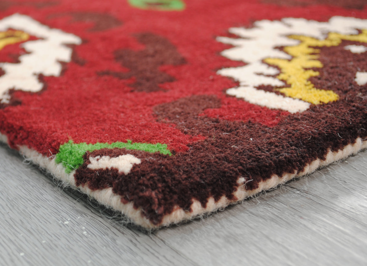 Corner of the Sambalpur rug showing the ivory wool-bound edge, no fringe