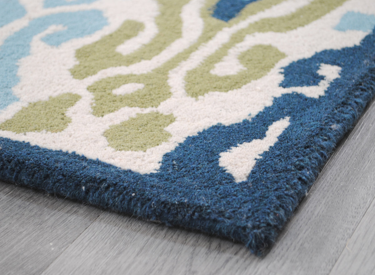 Corner of the Pochampally rug showing the indigo wool-bound edge, no fringe