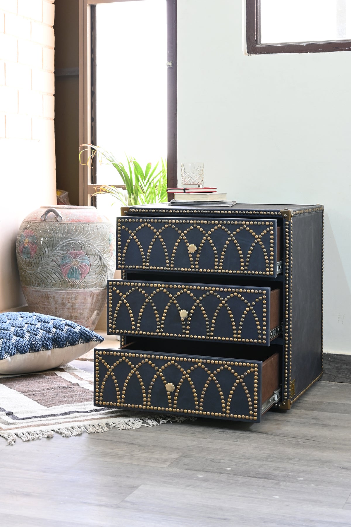 Samode bedside chest with drawers open, styled beside a carved urn and floor cushion