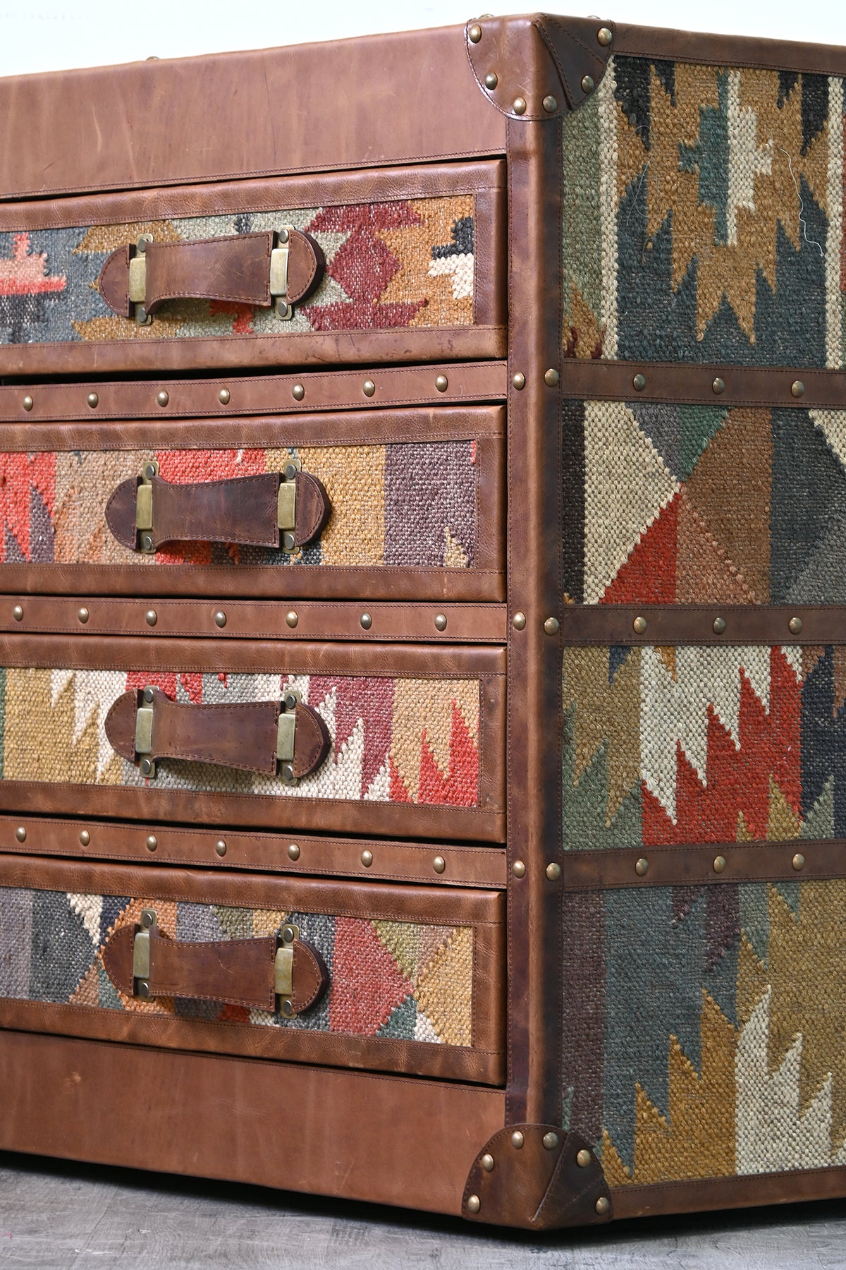Detail of the Chittor chest riveted corner cap, brass studs and vintage kilim flank panel