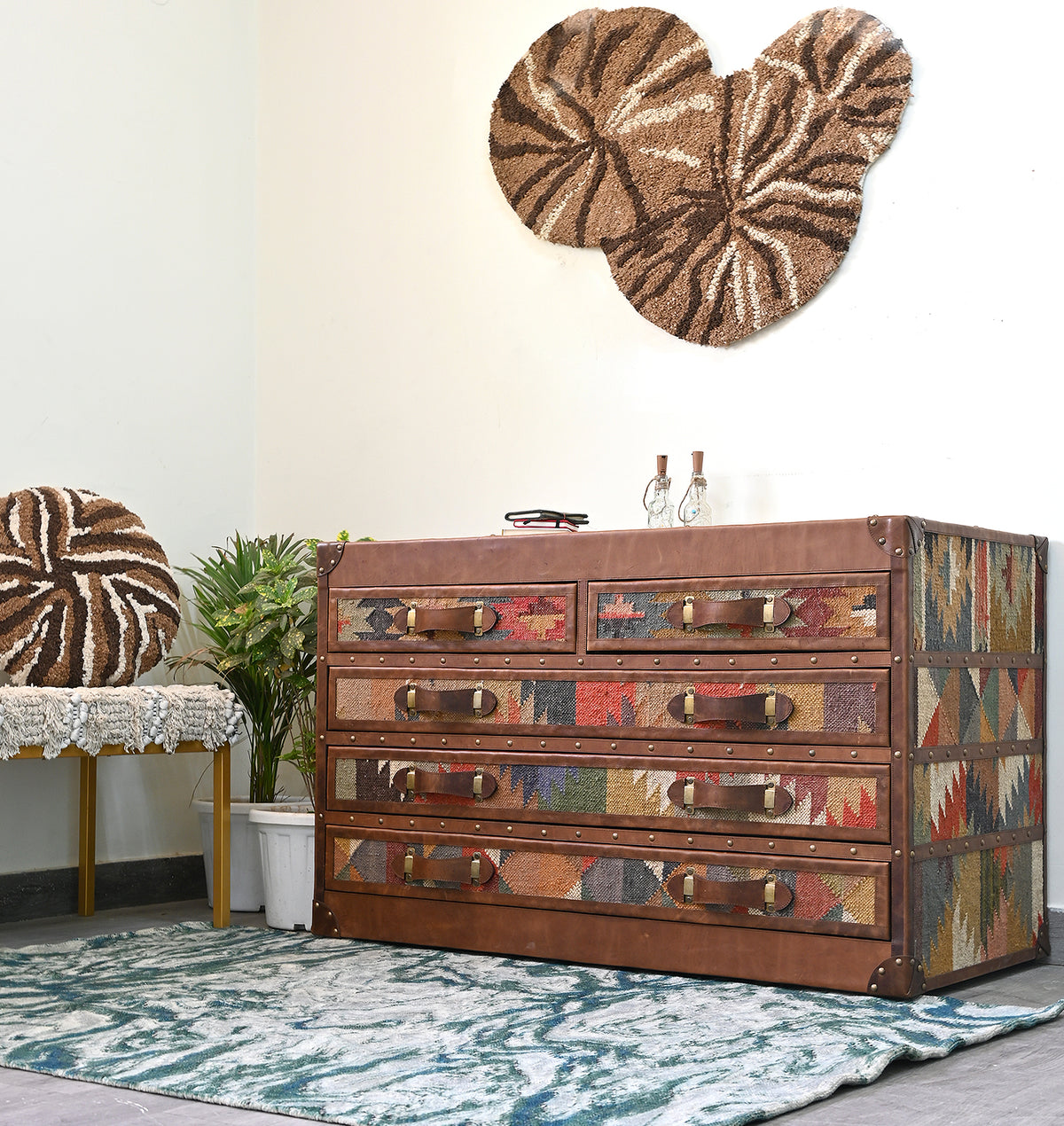 Styled view of the Chittor kilim and leather campaign chest beside a potted plant