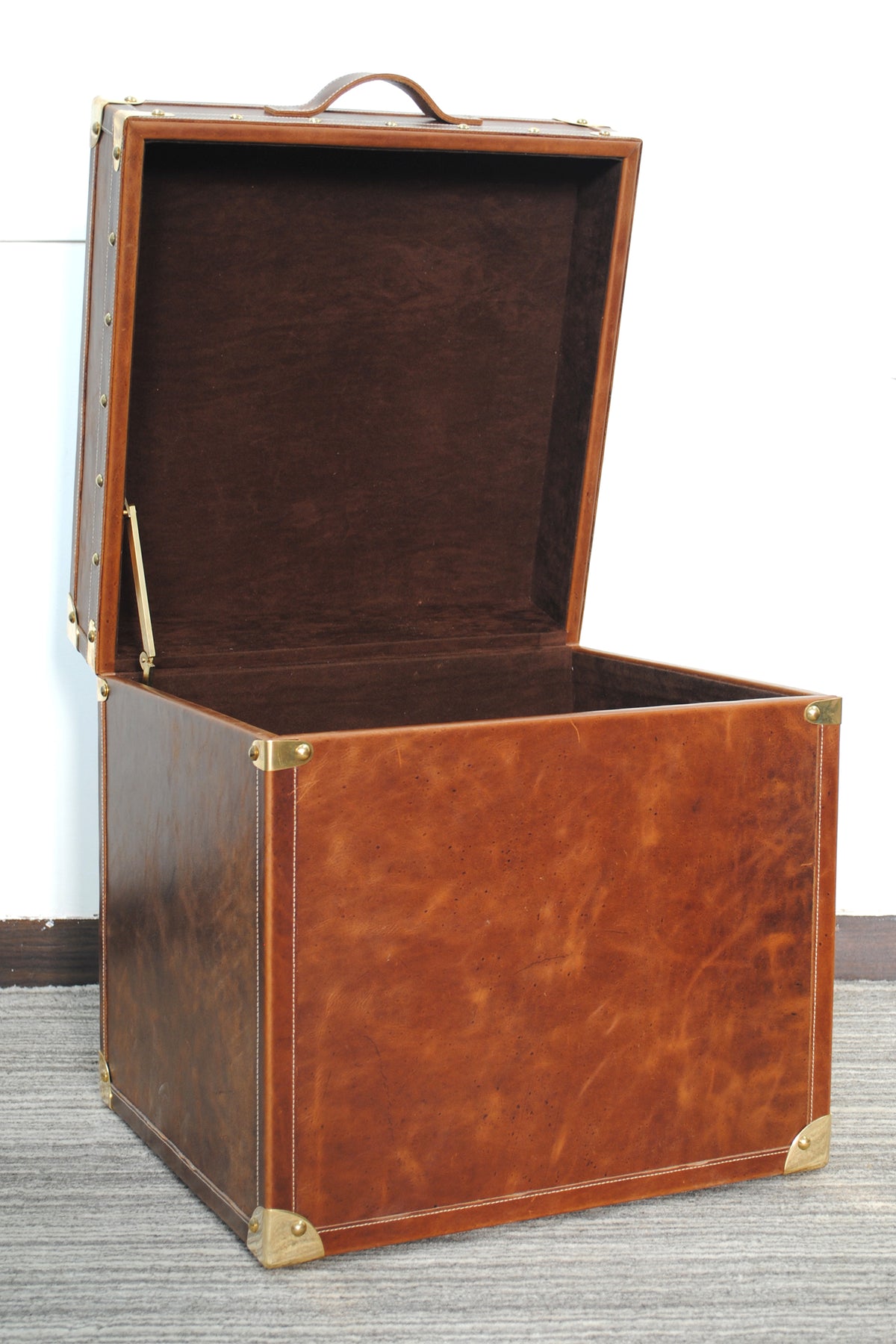 Cordoba Leather Cube Trunk with lid open, showing the chocolate suede-lined interior