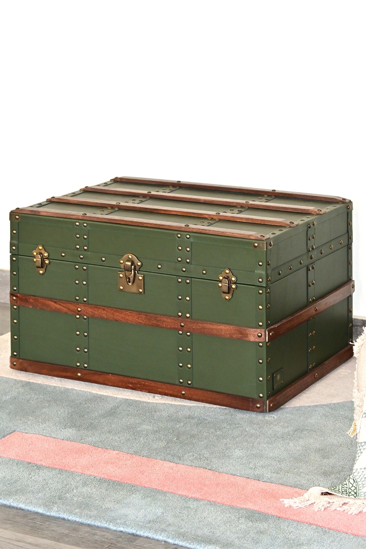 Three-quarter view of the closed green leather steamer trunk — Art Avenue