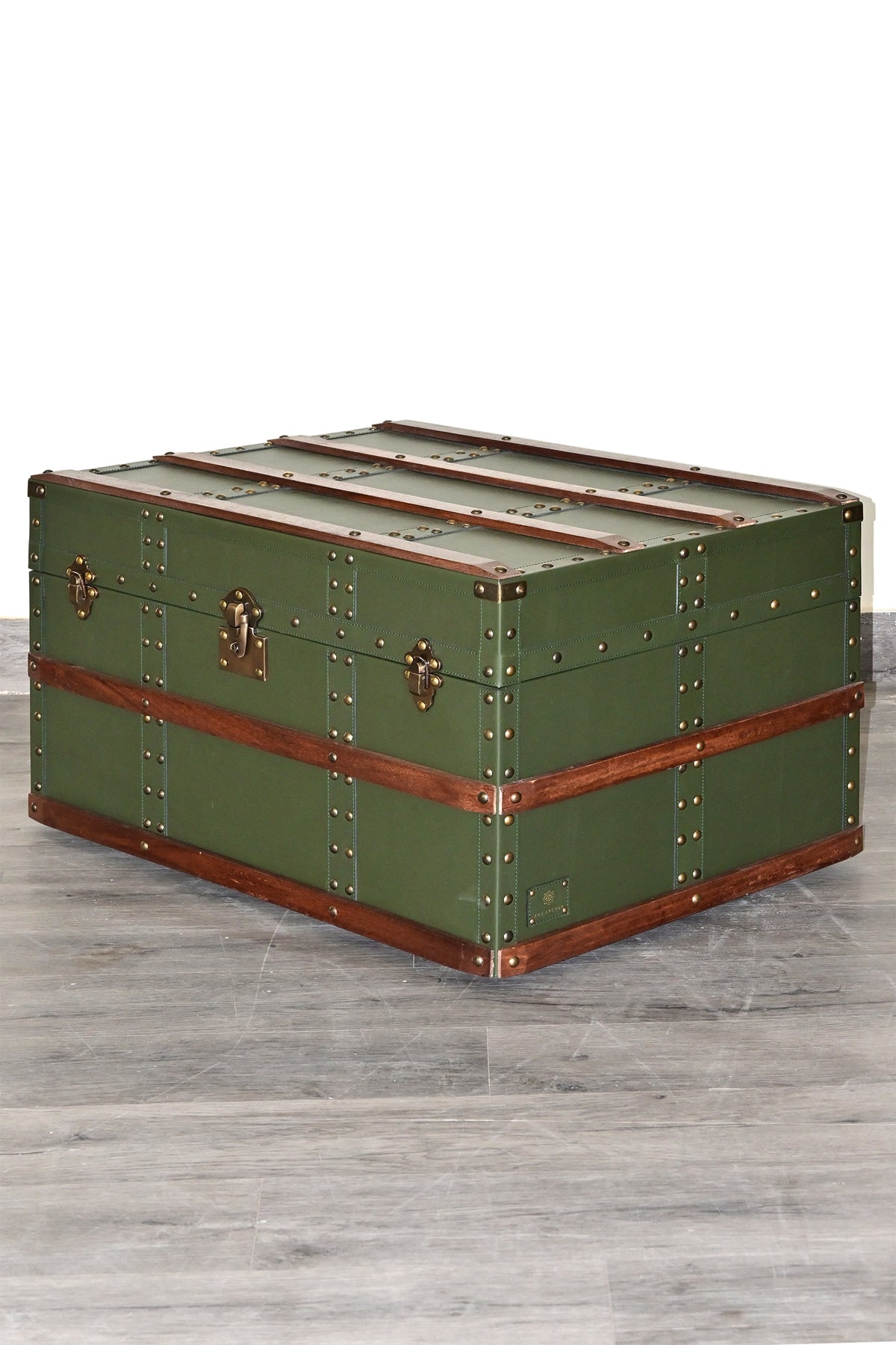 Three-quarter view of the Neemrana trunk showing studded straps and wood bands — Art Avenue
