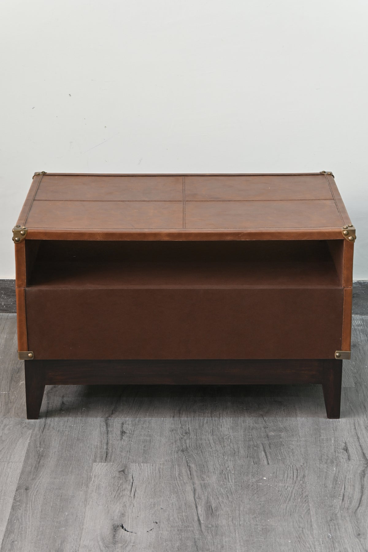 Rear of the Barmer TV unit, finished plain in leather with brass caps to the corners