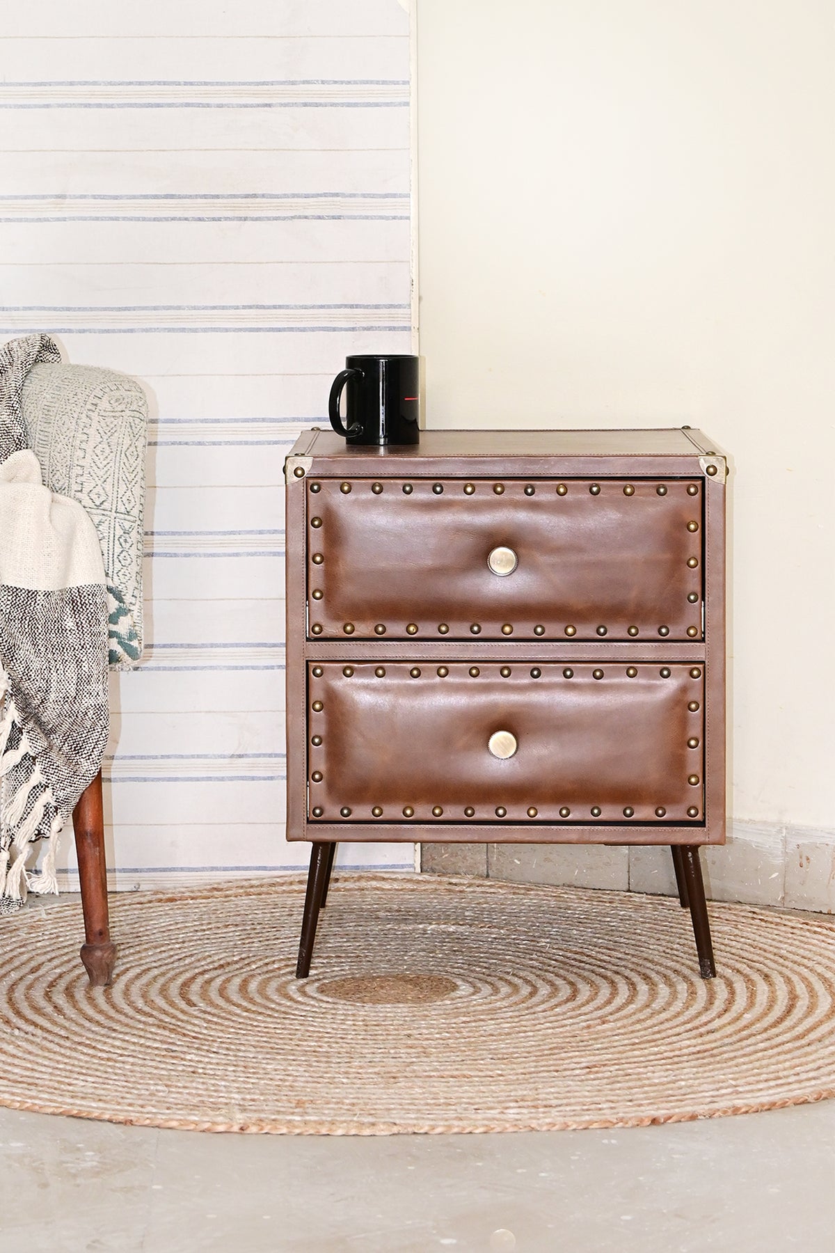 Kishangarh studded leather bedside table styled beside an armchair on a jute rug, Art Avenue, made to order