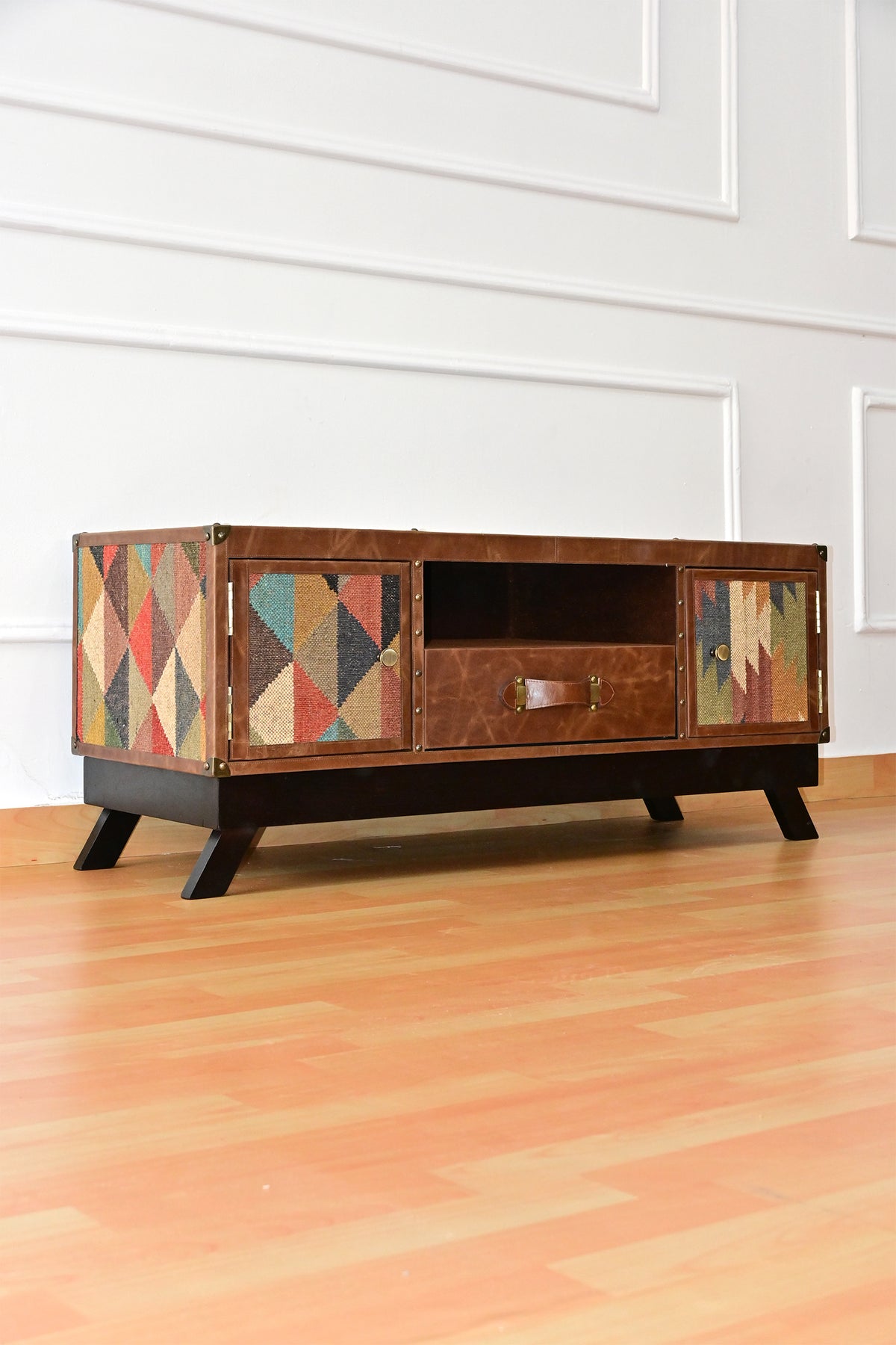 Karauli kilim and leather TV unit, three-quarter view showing kilim doors, centre drawer and splayed legs