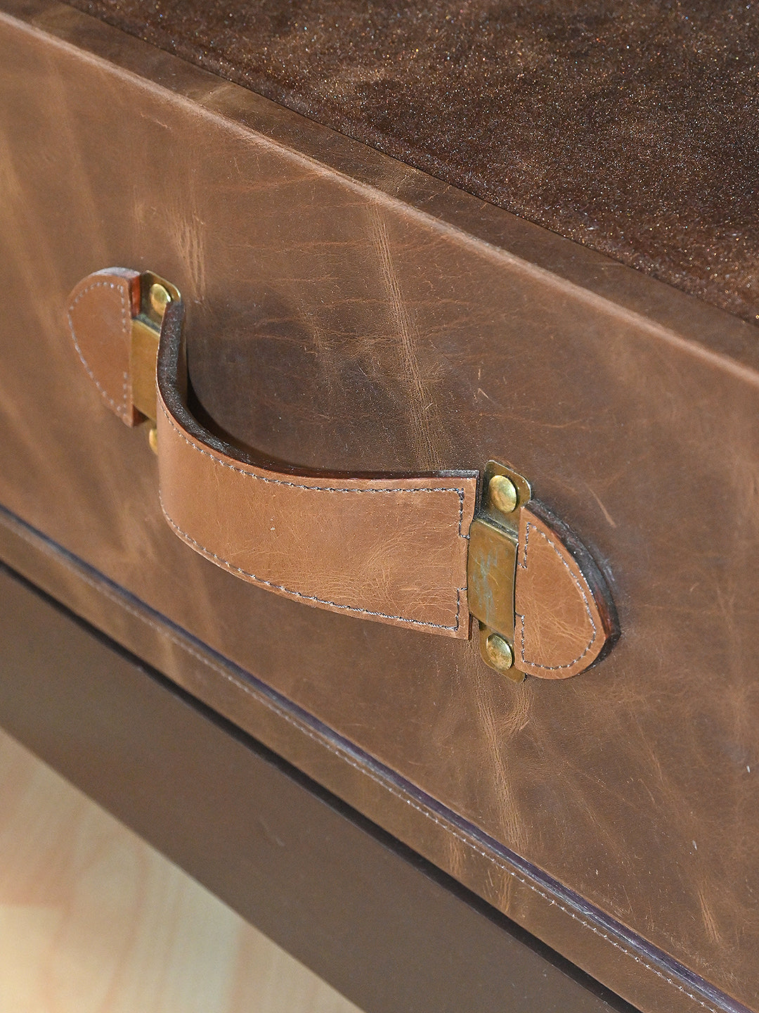 Stitched leather strap handle on brass mounts on the Mukundgarh drawer front
