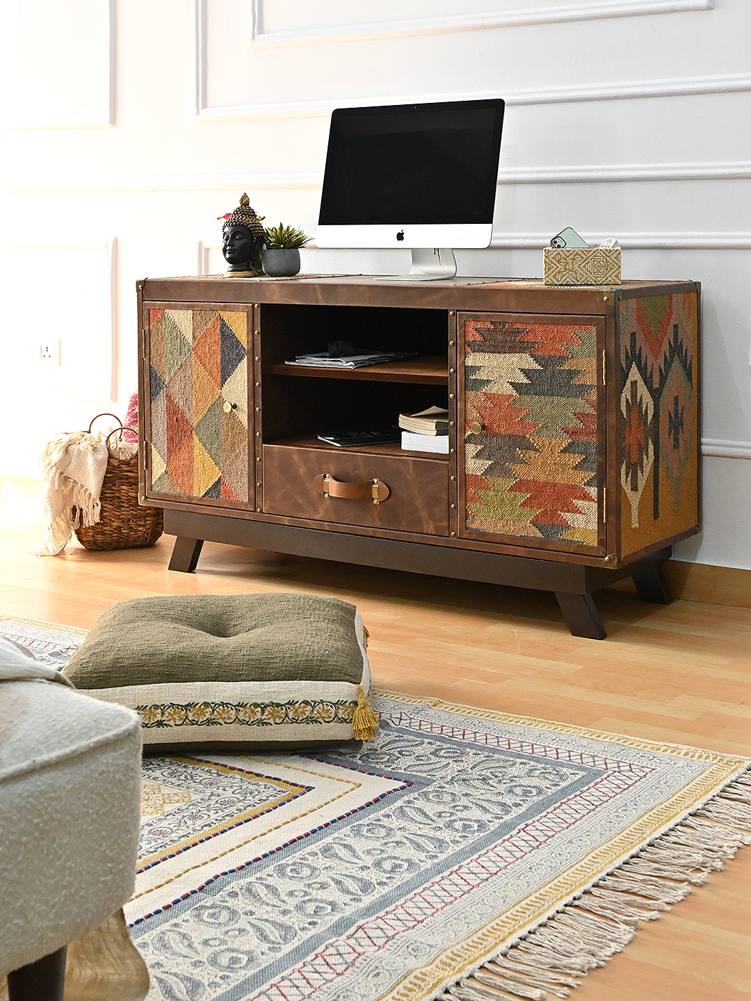 Mukundgarh TV unit by Art Avenue in a living room with a block-printed rug, floor cushion and woven basket