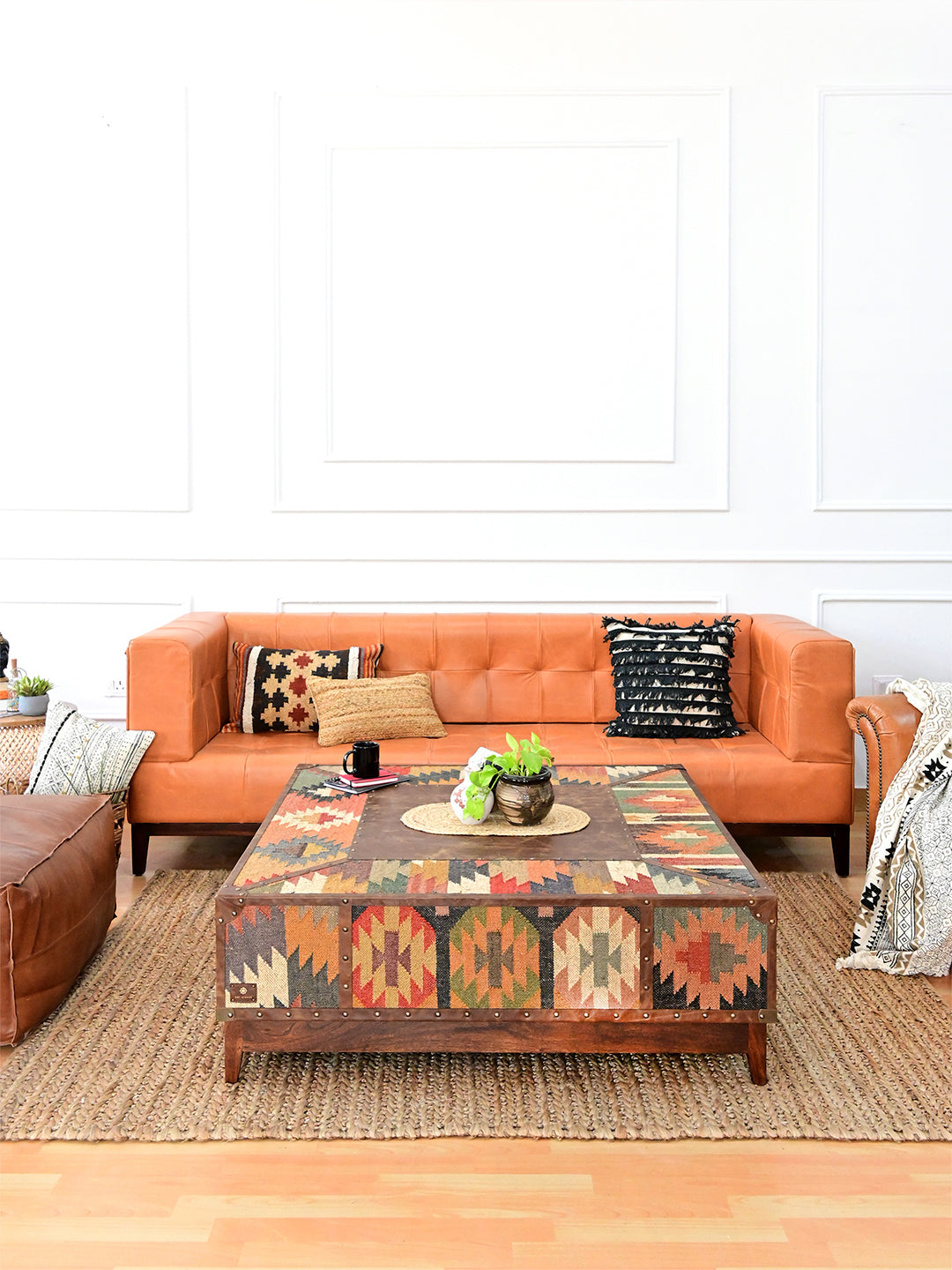 Wide living room view of the 120 cm Mandawa kilim coffee table between leather sofa and armchairs, Art Avenue