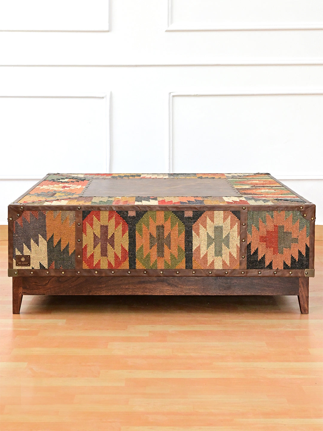 Kilim face of the Mandawa square coffee table, panels divided by studded leather straps, on a wood plinth, Art Avenue