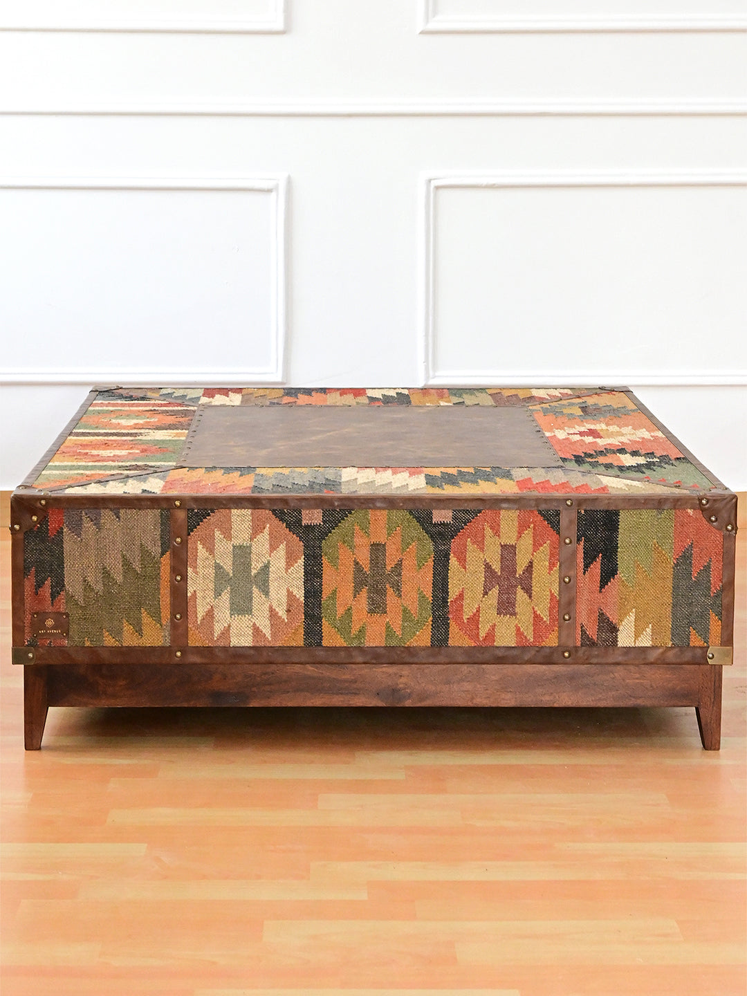Three-quarter view of the Mandawa 120 cm kilim coffee table showing a leather drawer face and a kilim face, Art Avenue