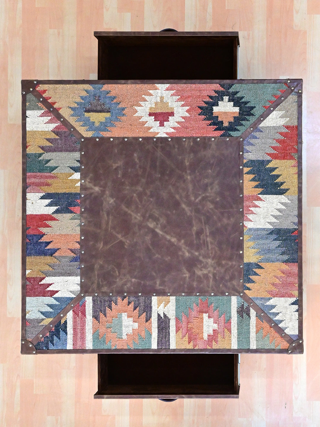 Overhead view of the Mandawa coffee table, leather centre framed by a four-panel kilim border, Art Avenue
