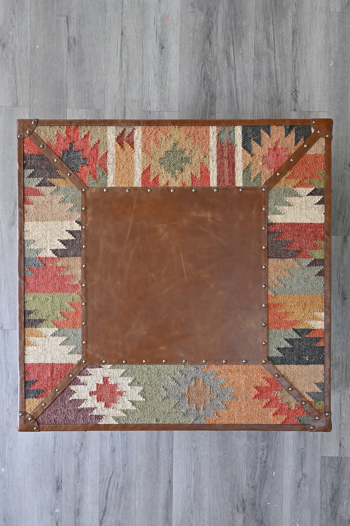 Overhead view of the Mandawa coffee table top, leather panel framed by kilim