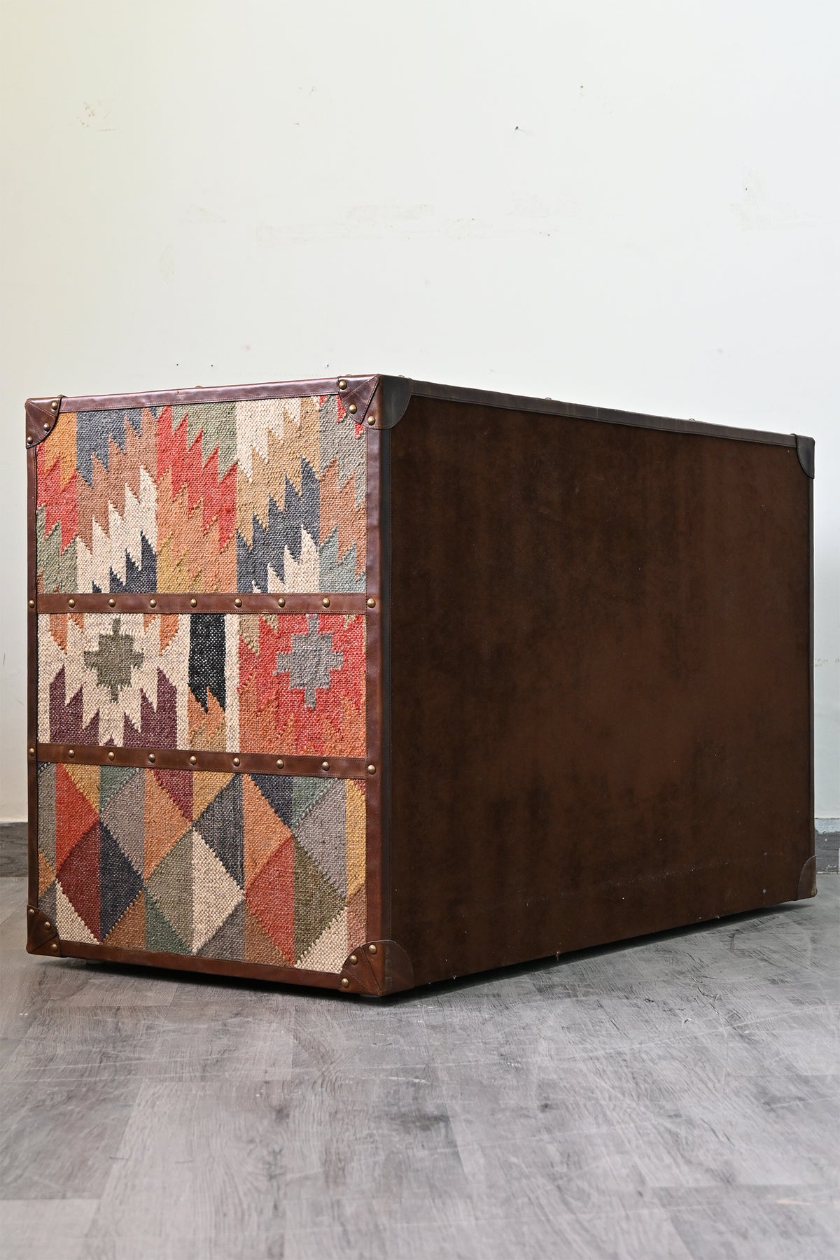 Rear three-quarter view of the Nimaj sideboard, kilim side panels and leather-bound brown back — Art Avenue