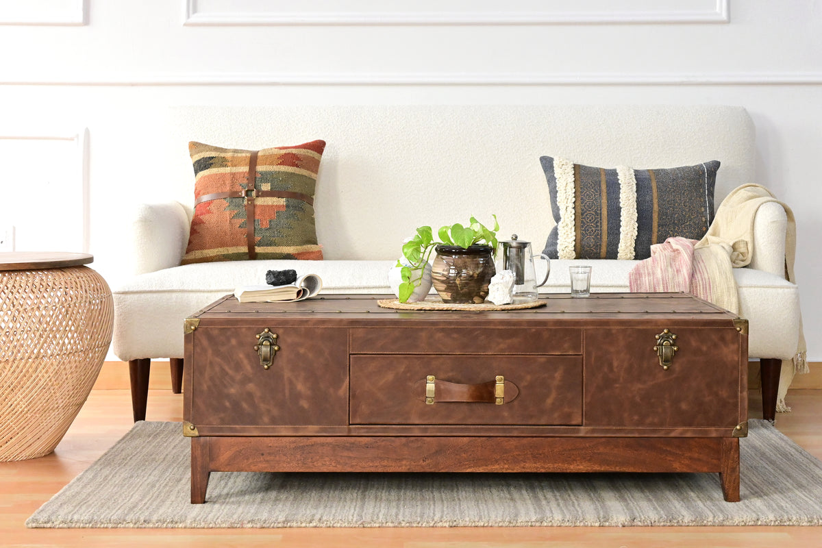 Nawalgarh leather trunk coffee table in a living room, wide front view with the drawer centred between two trunk catches