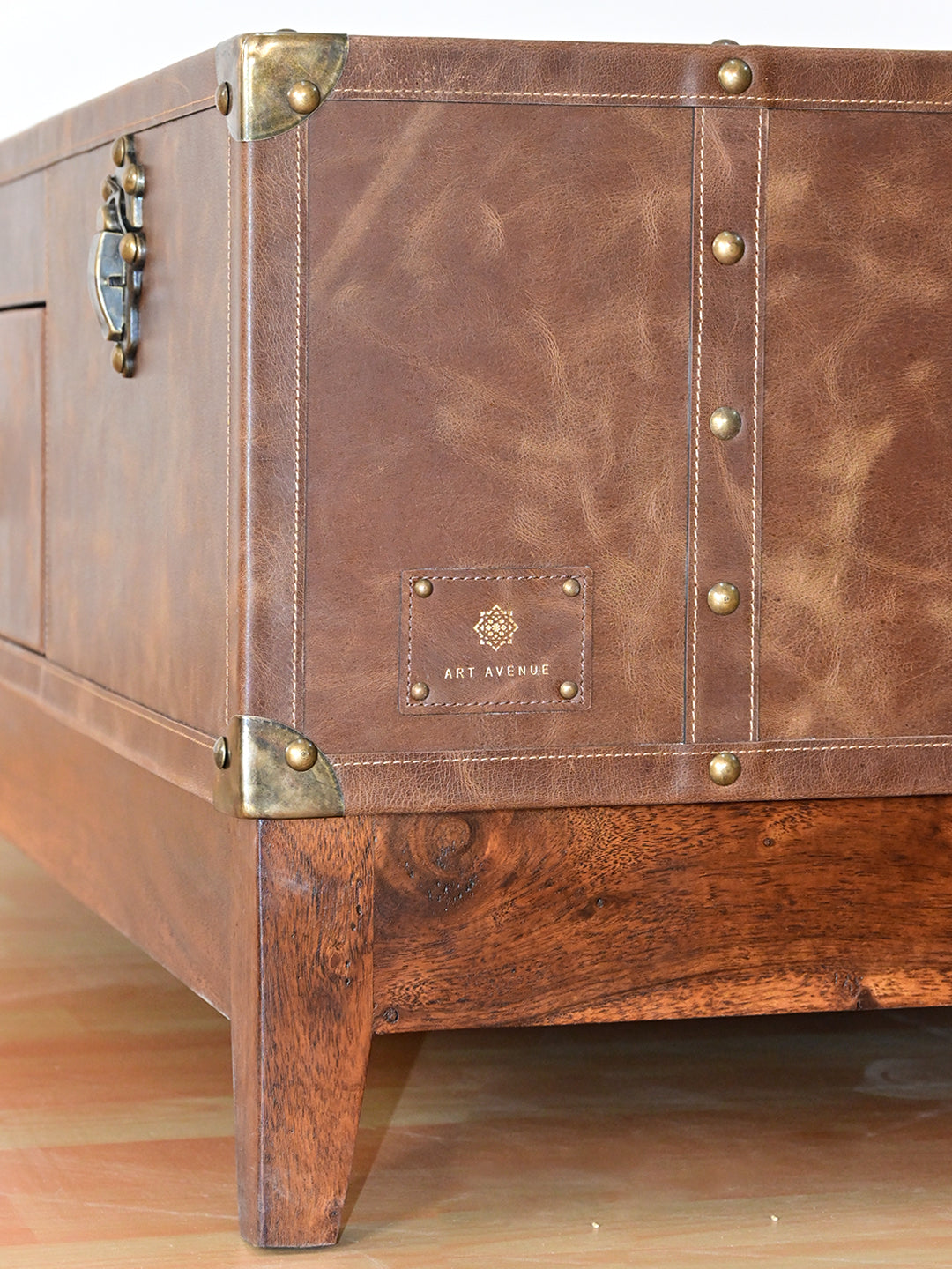 Nawalgarh leather trunk coffee table, corner detail: metal caps, saddle stitching and tapered solid wood leg
