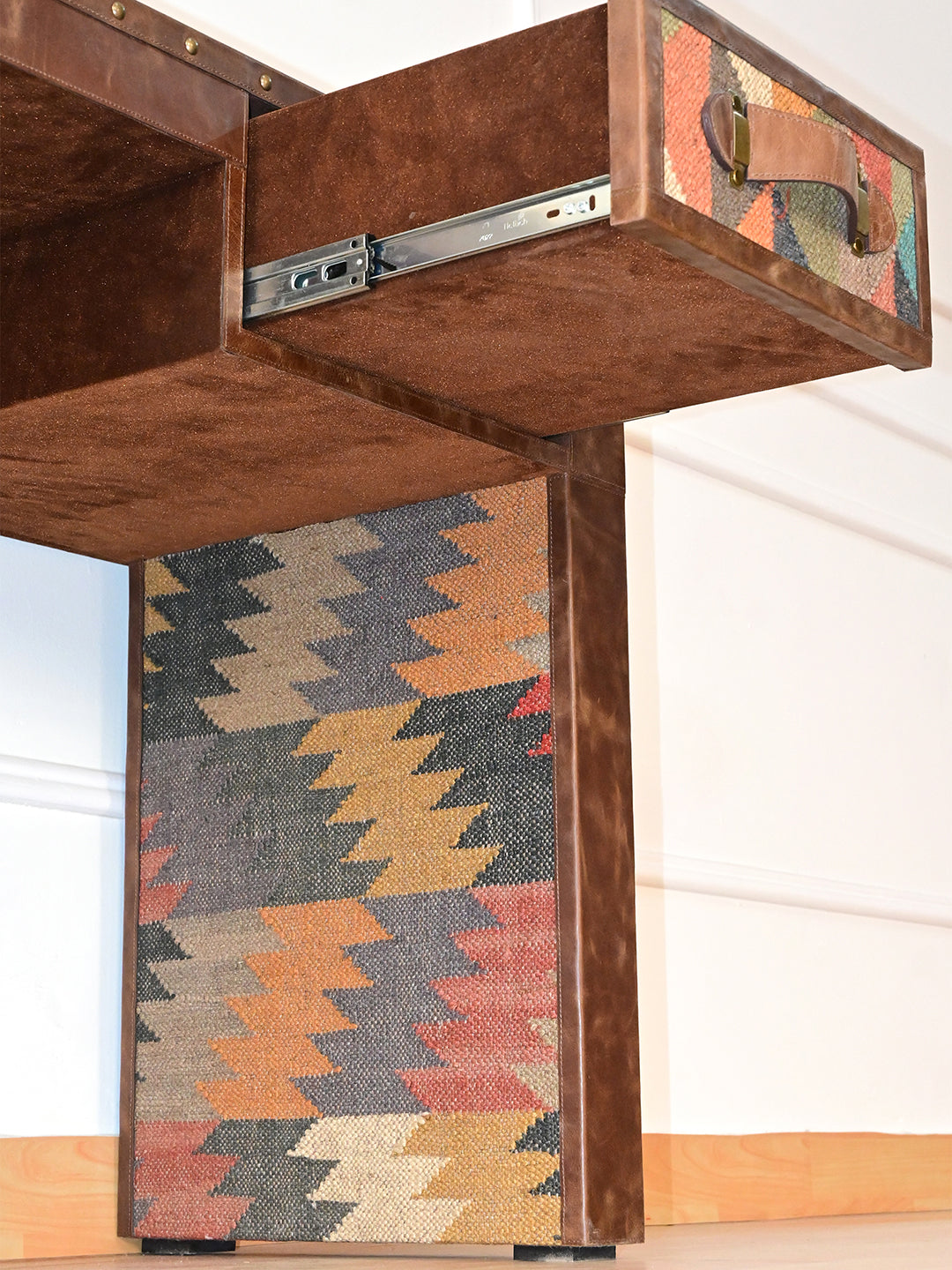 Suede-finished drawer housing and runner above the full-height inner kilim panel