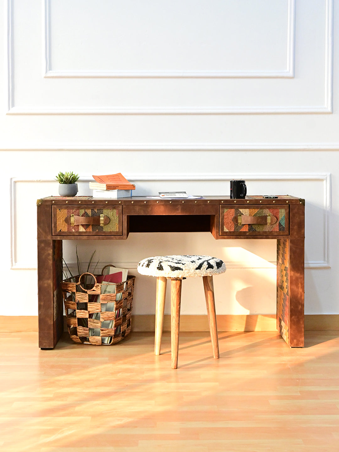 Dungarpur writing desk styled with books, a basket and a small stool against a panelled wall