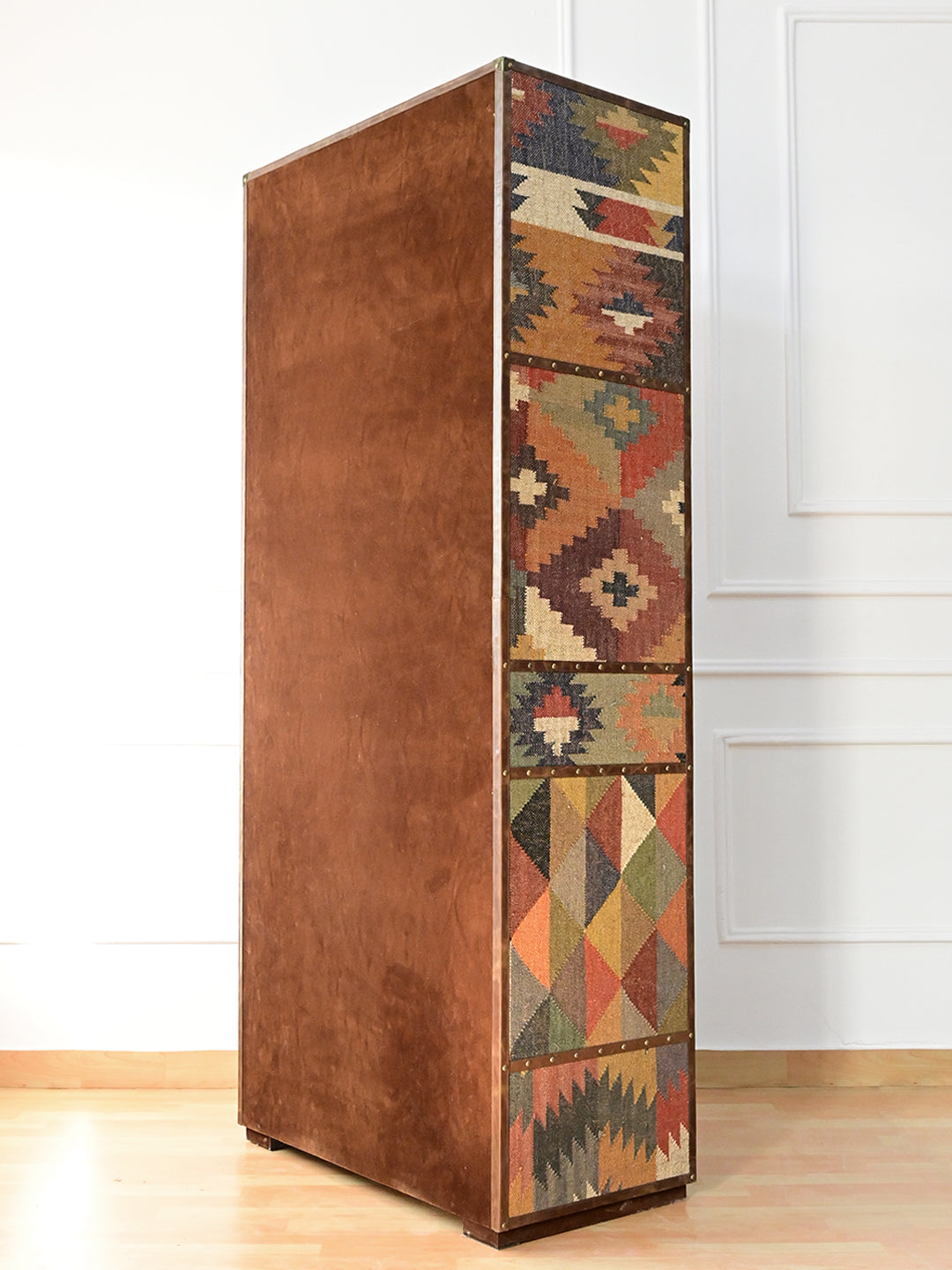 Rear three-quarter view of the Alsisar wardrobe showing the suede-finished back and kilim flank