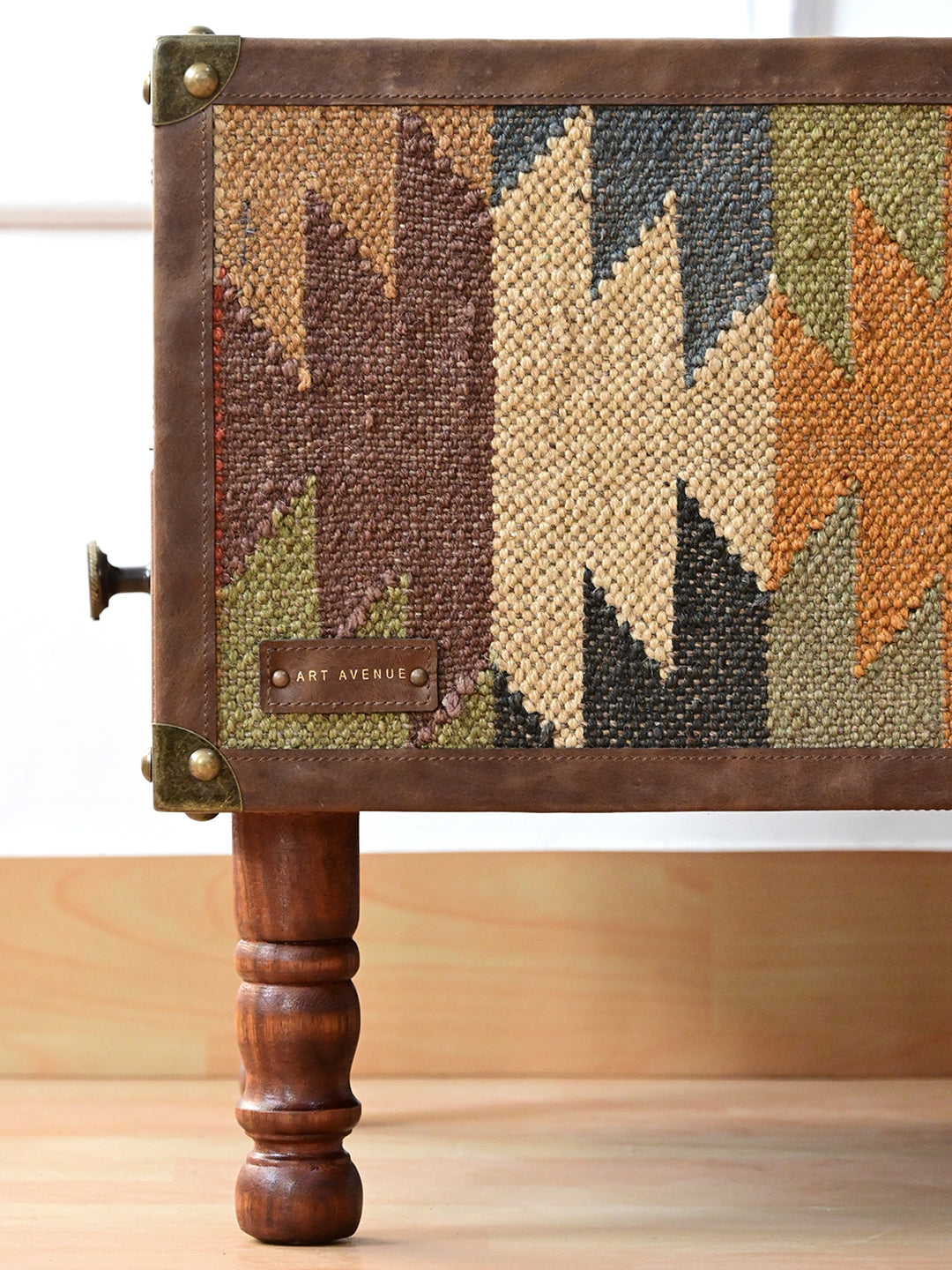 Close view of the Mahansar kilim side panel, leather binding, brass corner caps and turned leg
