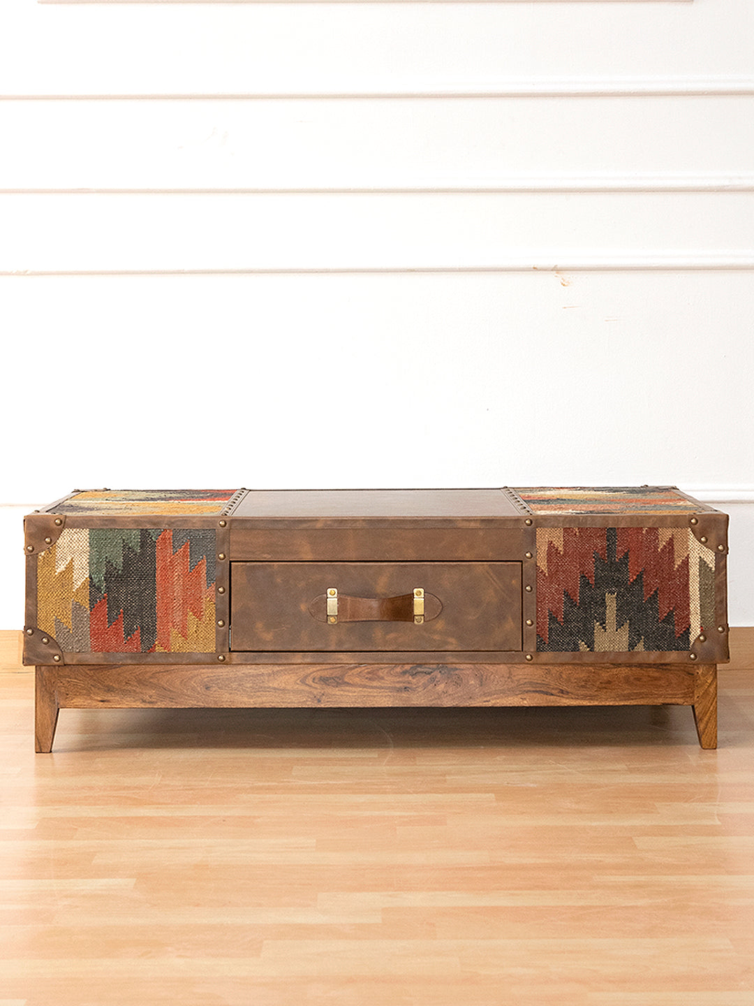 Sojat kilim and leather coffee table by Art Avenue, low front view showing the tapered solid wood legs