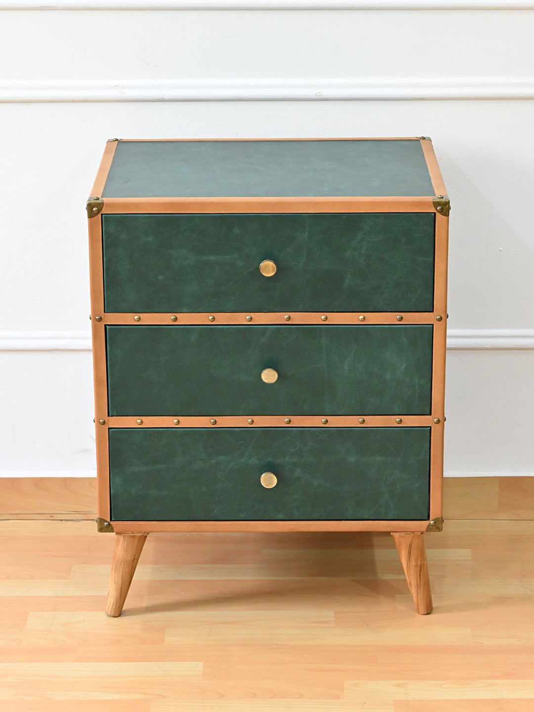 Sariska chest of drawers from a raised front angle, showing the green leather top framed in tan leather
