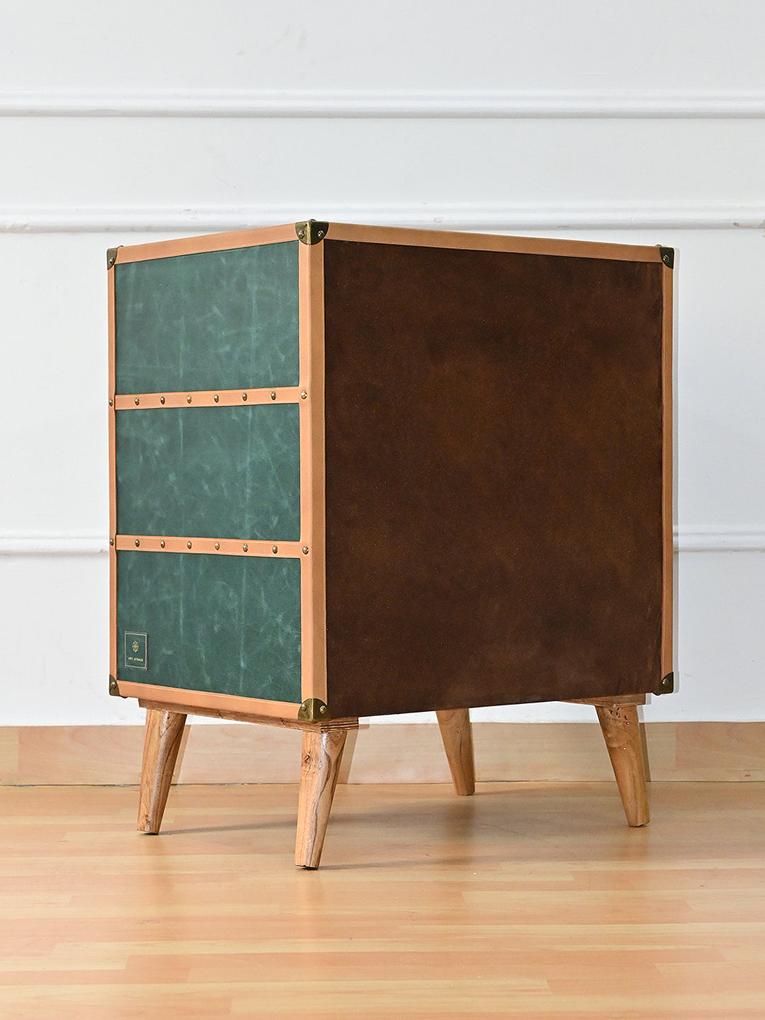 Rear three-quarter view of the Sariska chest of drawers showing the brown suede-finish back bound in tan leather