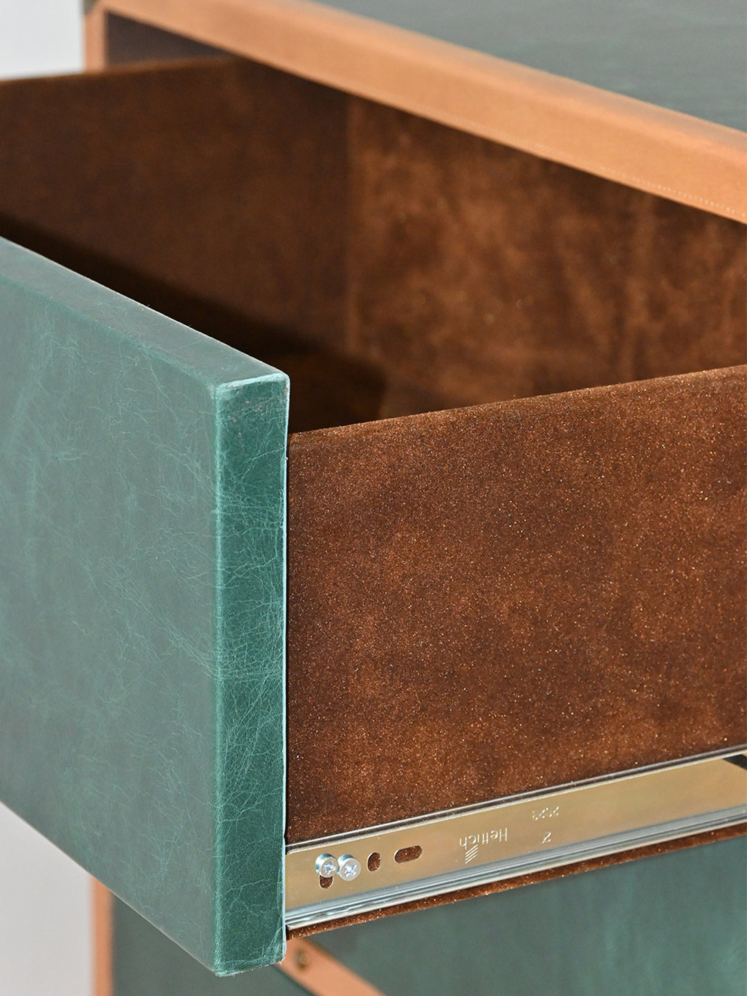Green leather drawer front and suede-lined drawer box of the Sariska chest, pulled out on its metal runner