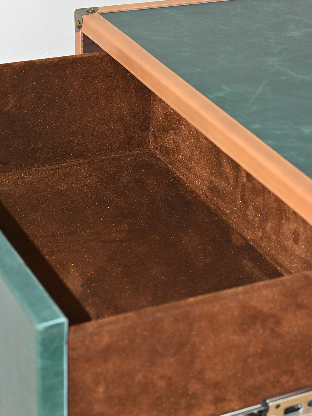Open Sariska drawer showing its brown velvet-nap suede lining and green leather drawer front
