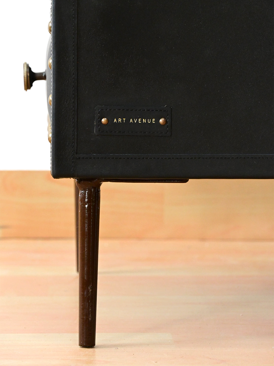 Detail of Art Avenue leather maker's tag and dark bronze tapered leg, Kishangarh bedside table in Onyx