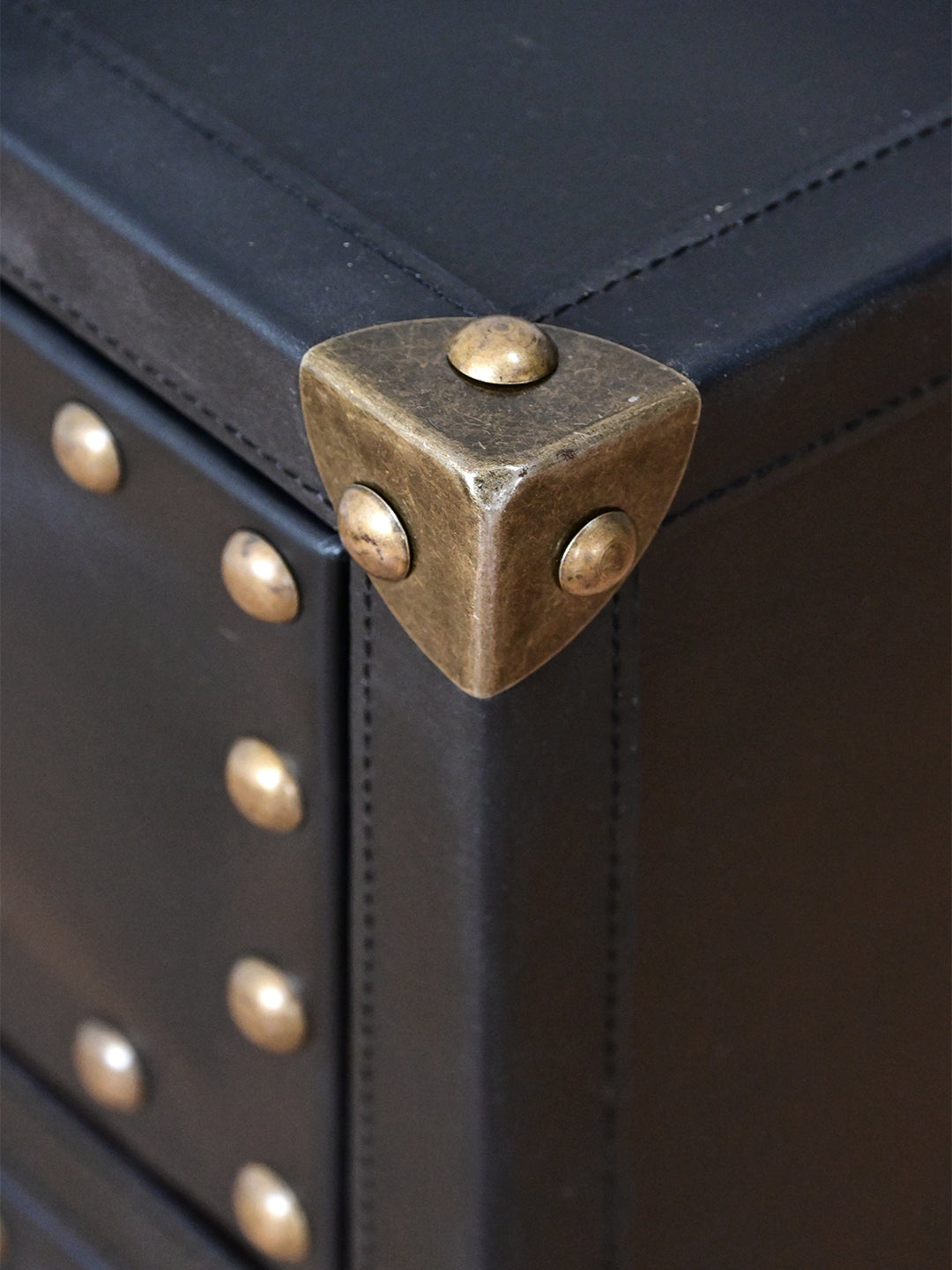 Detail of antique brass corner cap on saddle-stitched Onyx leather, Kishangarh bedside table, Art Avenue